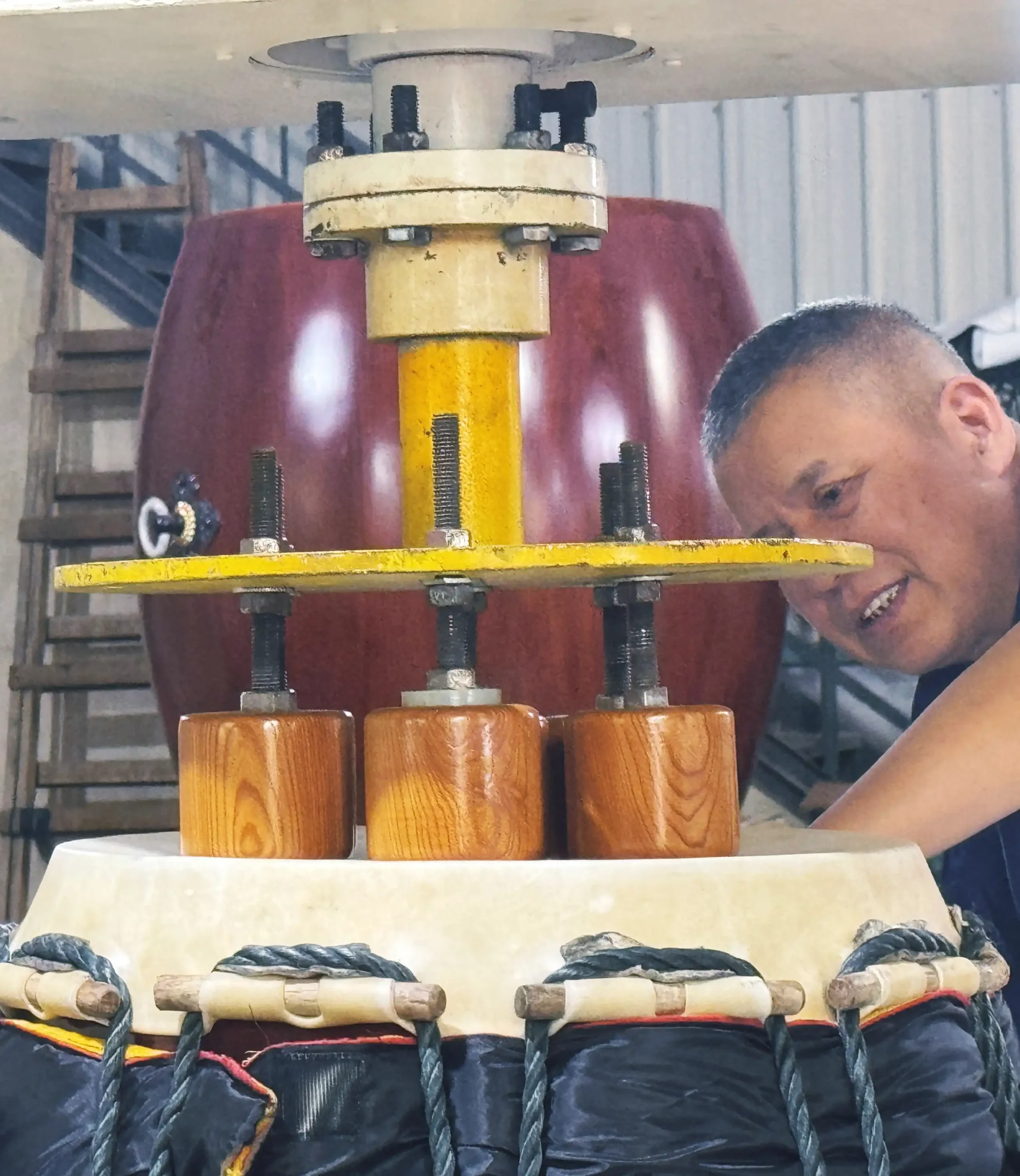 JINLEI craftsperson completing final taiko skin stretching and sound adjustment