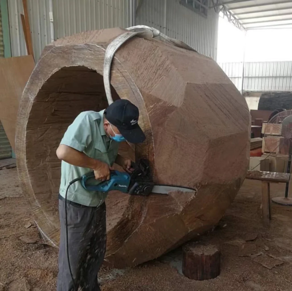 Worker using specialized equipment for external cutting of a Taiko drum shell.