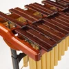 JINLEI marimba MLP-52 close-up of rosewood bars with cord stringing, gold resonator tube openings, and cherry wood frame rail detail