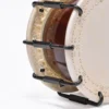 Close-up of JINLEI 2Cyoukake Shime Daiko Turnbuckle drum showing stitched leather drumhead rim, black metal turnbuckle tension hardware with U-shaped hooks and threaded adjustment rods against amber lacquered wood shell