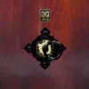 Close-up of JINLEI Nagadou Daiko Kapiac drum decorative hardware featuring gold floral ring pull on black cast iron diamond-shaped mount against deep reddish-brown kapiac wood surface