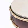 Close-up of JINLEI O-Hira Daiko Kapiac drum showing double-row black bead tacking, natural rawhide lacing and ornate black cast iron diamond hardware with gold accent against glossy deep burgundy kapiac wood shell