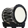 JINLEI O-Shime daiko, glossy black shell with white rope tuning and natural cowhide drumhead on black stand, side angle view