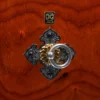 Close-up of Nagado Daiko African Padauk hollowed-out solid wood drum decorative hardware featuring gold and silver ring pull on black cast iron diamond-shaped mount against rich reddish-orange wood grain
