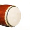Side angle view of Nagado Daiko Ash Wood hollowed-out solid wood drum showing cowhide drumhead with black bead tacking and glossy reddish-brown ash wood shell
